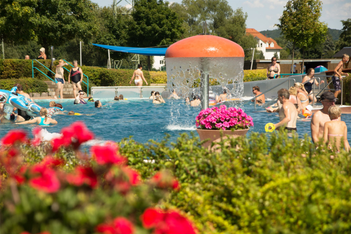 belebtes Schwimmbecken mit Badegästen